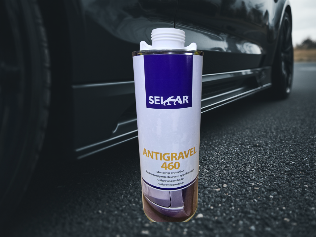 ANTI GRAVILLON BLANC 1 - PredaColor Spray can labeled Antigravel 460 for stonechip protection placed on asphalt beside a parked car.