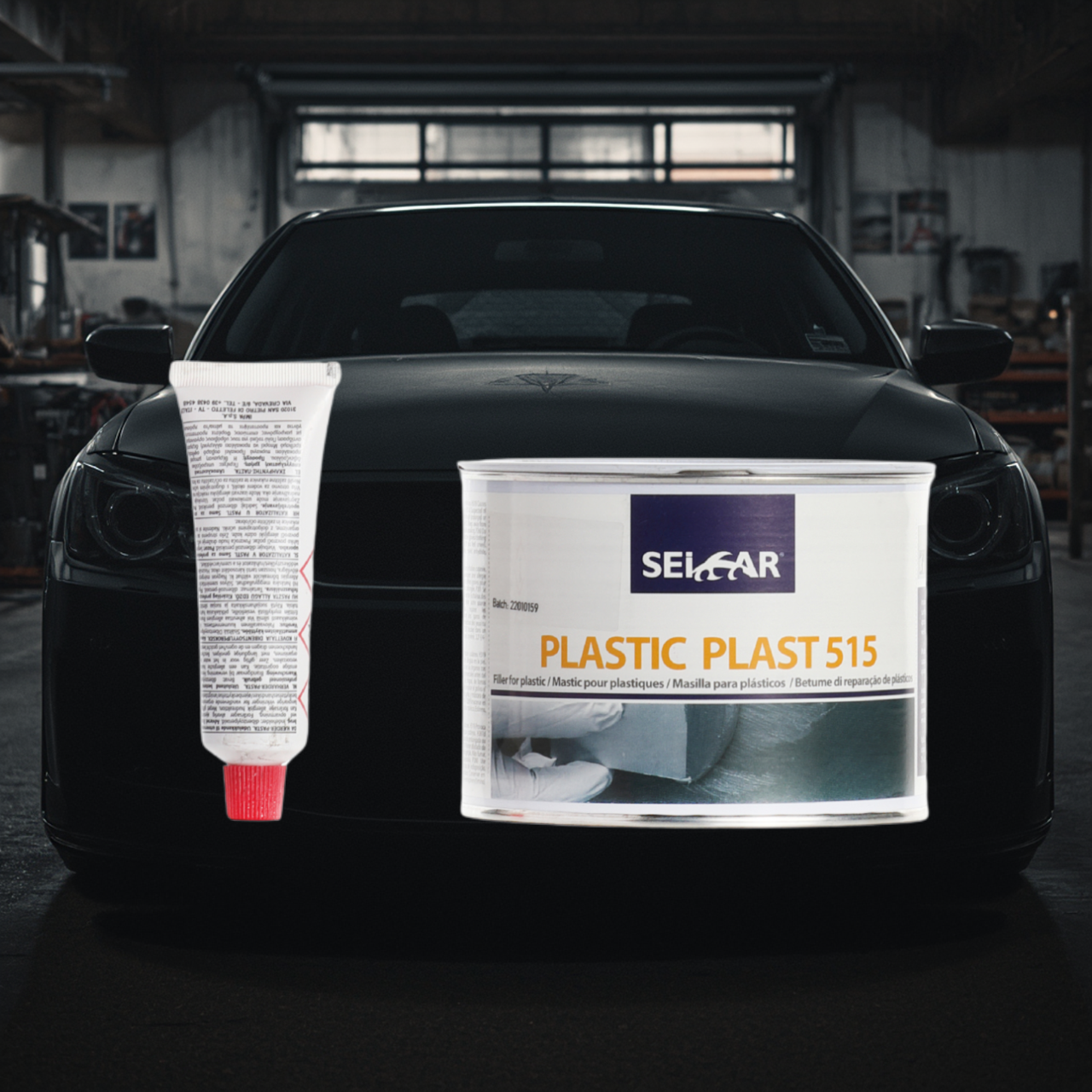 Arrière-plan avec pare-chocs en plastique - PredaColor Black car in a workshop with large plastic repair cans attached to the front, labeled SEICAR Plastic Plast 515 and a tube of adhesive visible on the left side.