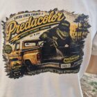 4 2 - PredaColor White T-shirt featuring a vintage-style graphic: a yellow and black pickup with a dinosaur rider and bold 'Predicolor' text across the top, palm trees in the background.